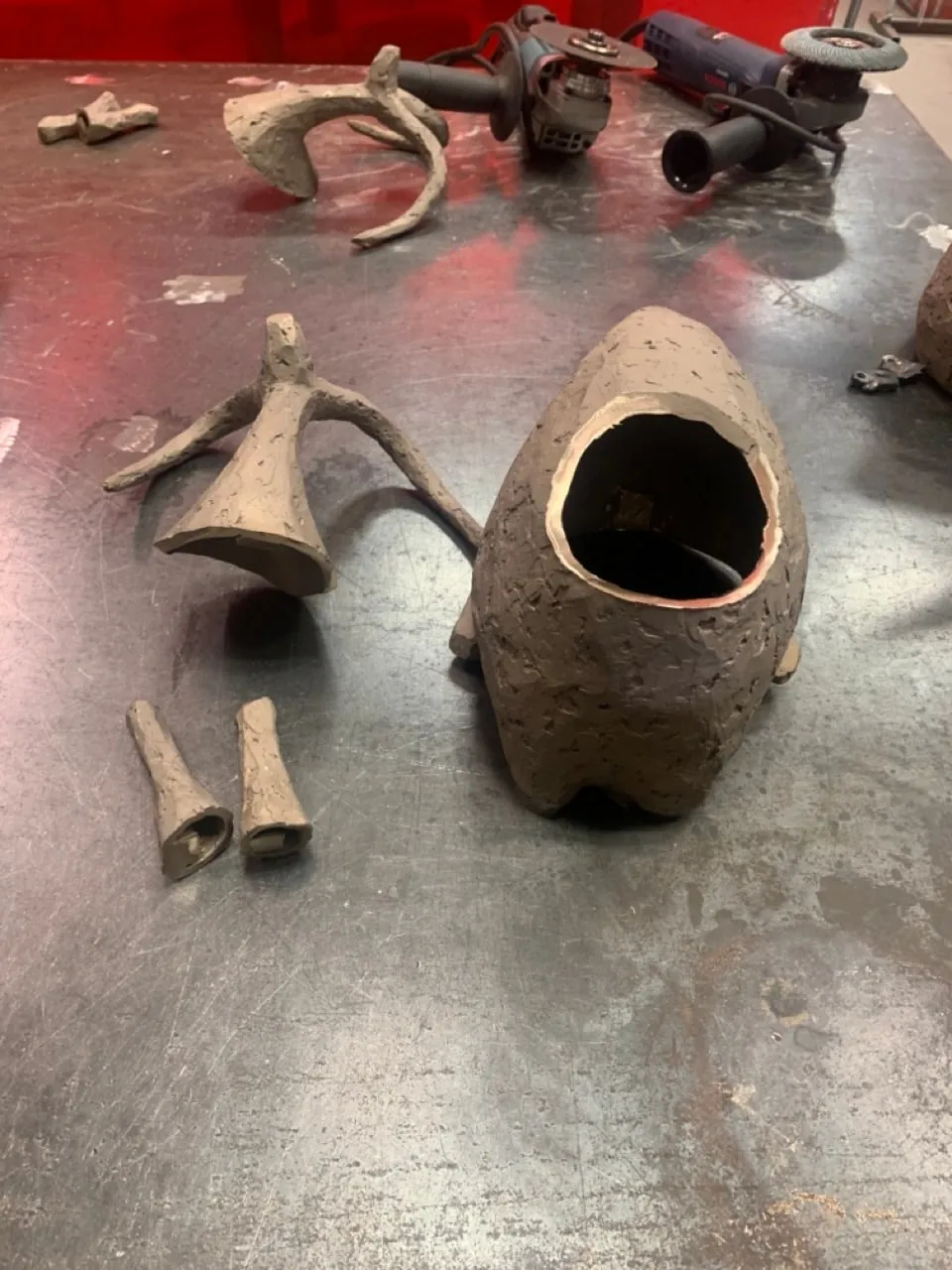 Hollow cast bronze parts laid out on a steel bench