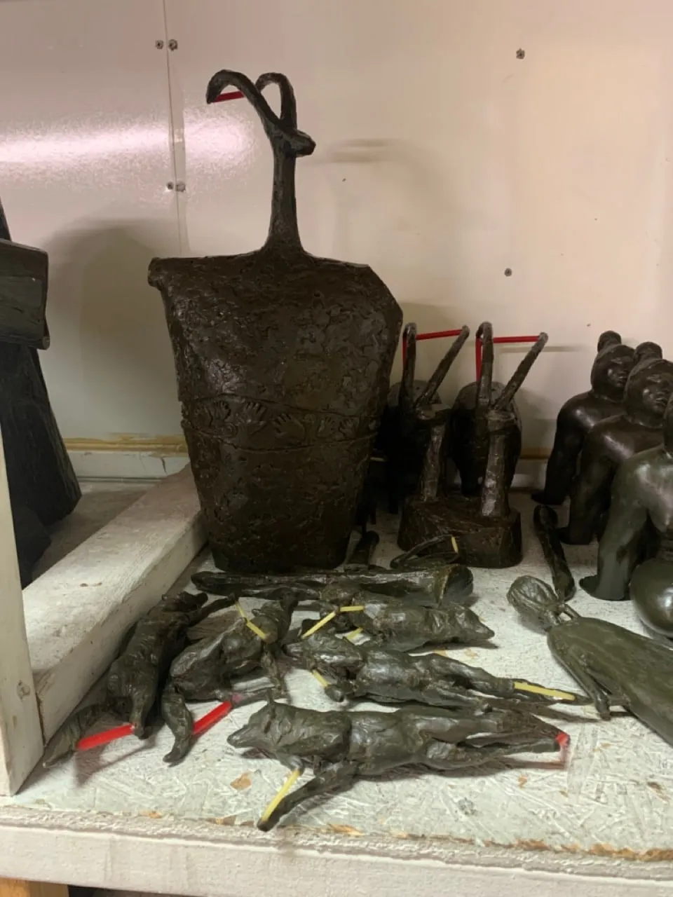 Wax pieces on a foundry shelf, some with sprues attached