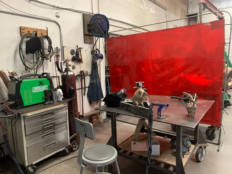 The welding bench with tools and small bronzes on it